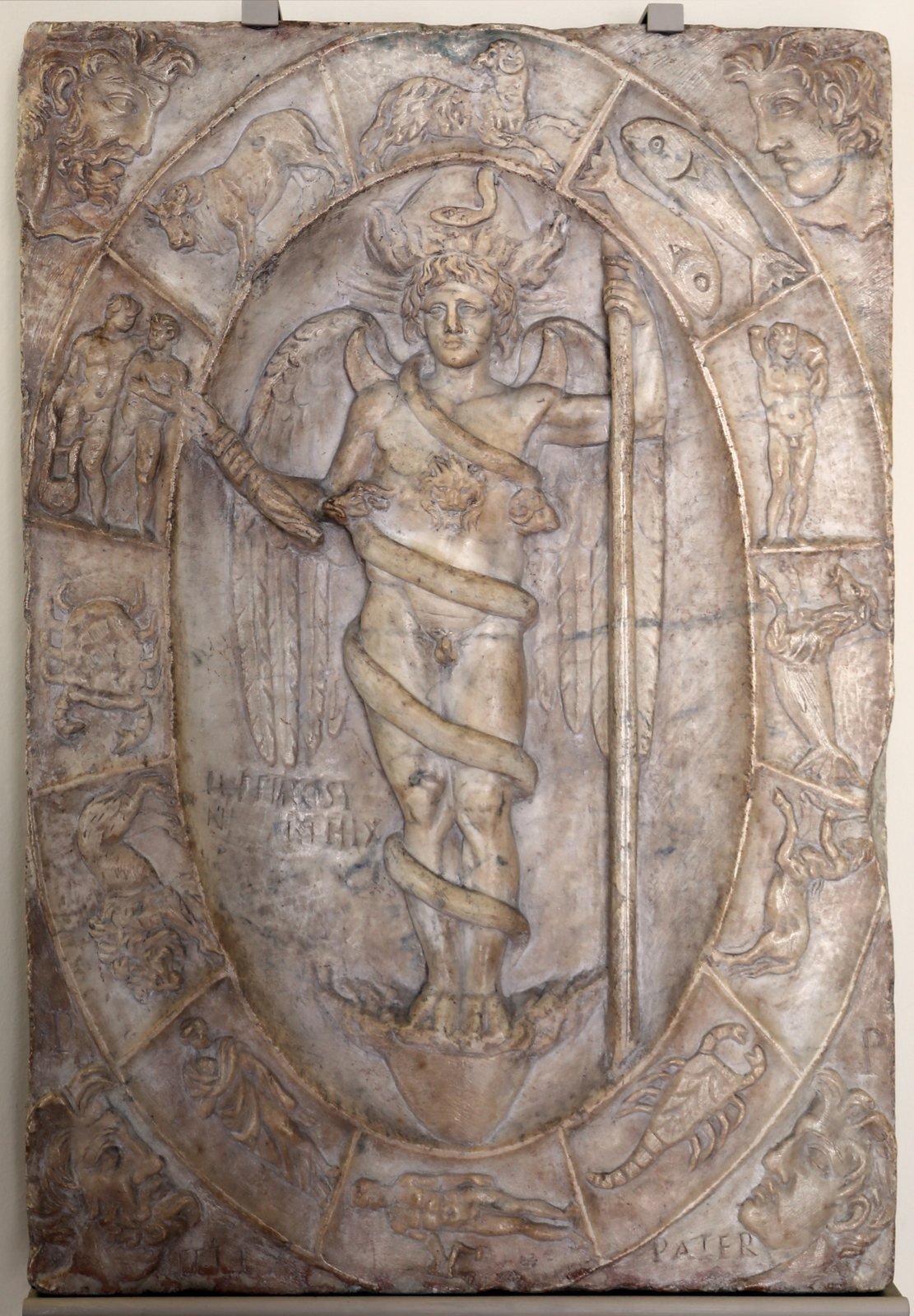 Roman marble relief, about AD 150, usually identified as the Orphic Phanes. The winged god stands between the two halves of the egg he hatched from, with flames bursting from the shells, a snake coiled around him and the twelve signs of the zodiac circling him.