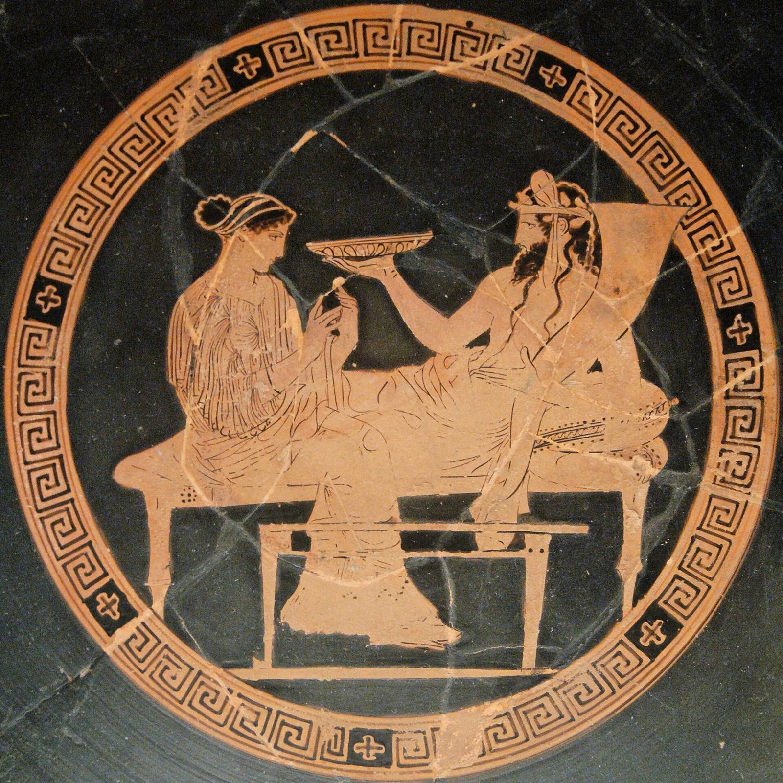 Athenian red-figure cup, about 440 to 430 BC, painted by the Codrus Painter. Plouton lies on a banqueting couch with a horn of plenty behind him and holds out a bowl, while his queen Persephone sits at the end of the couch.