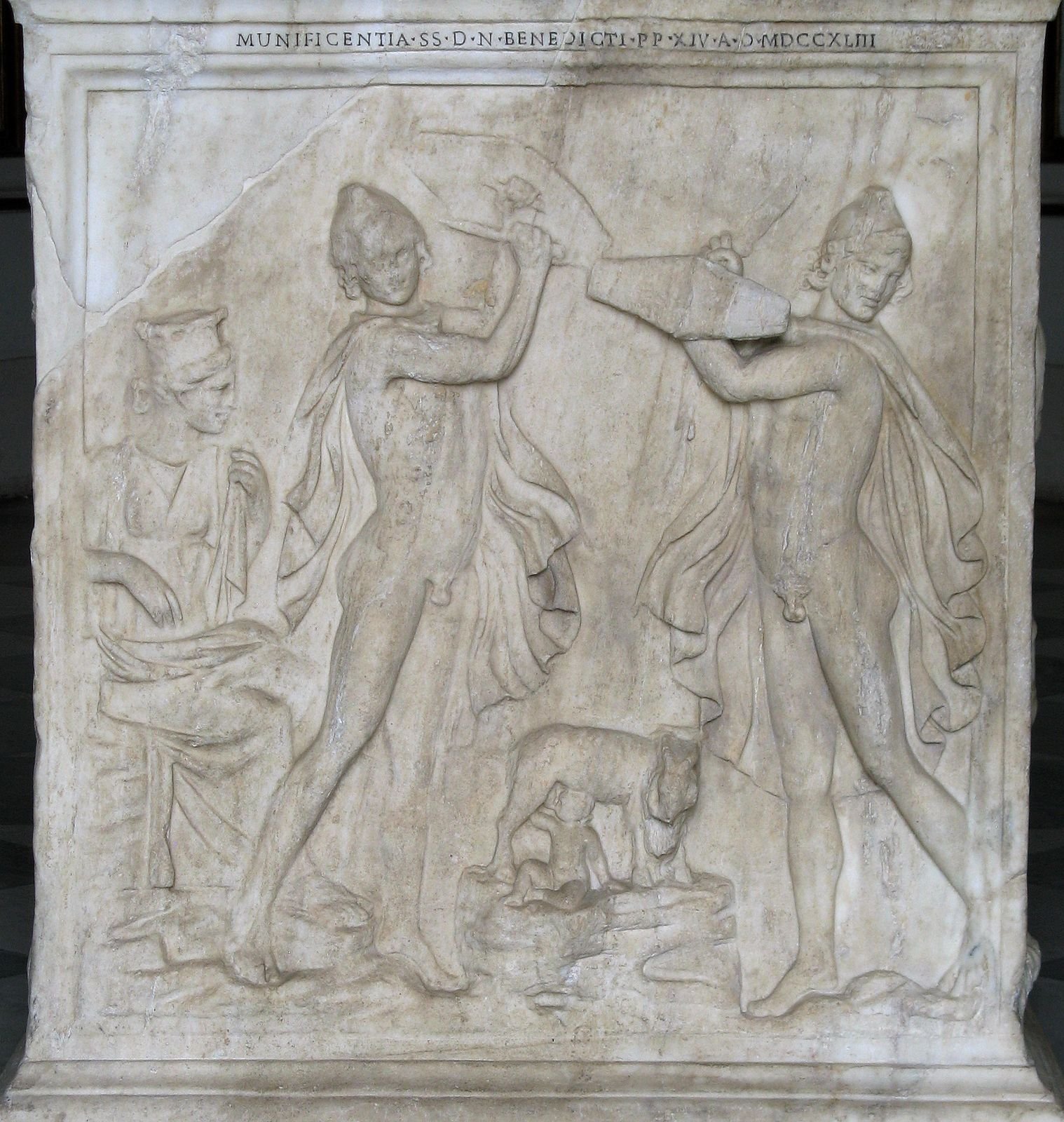 Roman marble base, 2nd century AD. Two Kouretes dance with swords and shields while the goat Amalthea nurses the infant Zeus; their noise kept his father Kronos from hearing the baby cry.