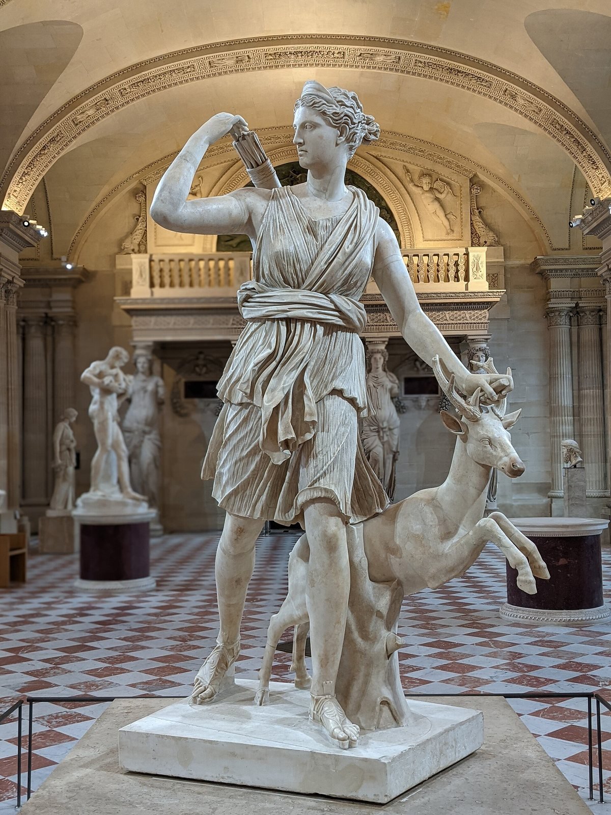 Artemis with a deer, known as the Diana of Versailles, Roman marble of the 1st or 2nd century AD after a Greek original of about 325 BC. The huntress strides forward and reaches over her shoulder for an arrow, with a deer leaping at her side.