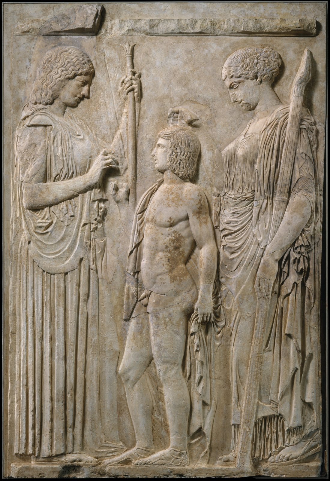 Ten fragments of a Roman marble copy, about 27 BC to AD 14, set into a cast of the Great Eleusinian Relief found at Eleusis. Demeter, on the left with her scepter, and her daughter Persephone, holding a long torch, stand on either side of a boy usually identified as Triptolemos, whom Demeter sent to teach people to grow grain.