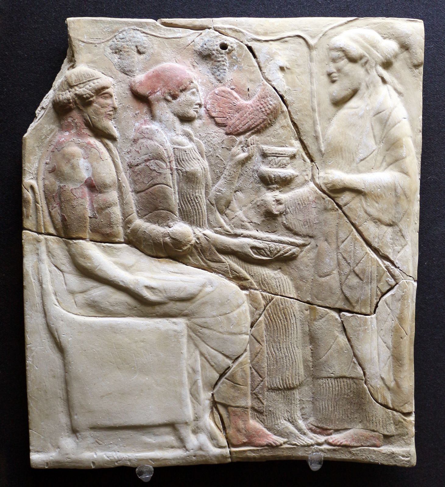 Clay votive plaque from Locri in southern Italy, early 5th century BC. Dionysus offers a wine cup to Hades and Persephone, who sit enthroned as rulers of the underworld.