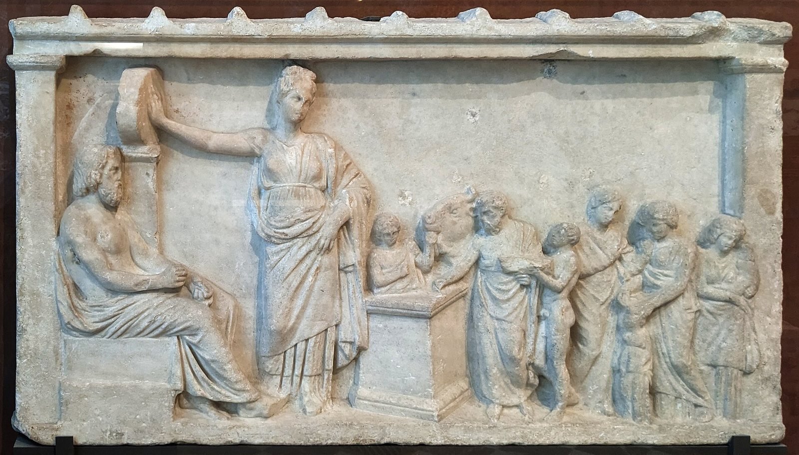 Marble offering relief from Attica, 350 to 300 BC. Asclepius sits on his throne at the left with Hygieia standing beside him, while a family comes to pray and a servant brings a bull to the altar.